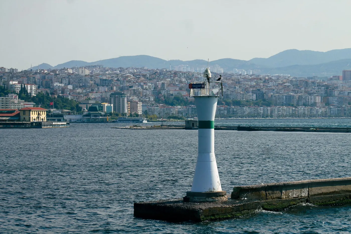 İzmir kıyısında deniz feneri ve körfez manzarası